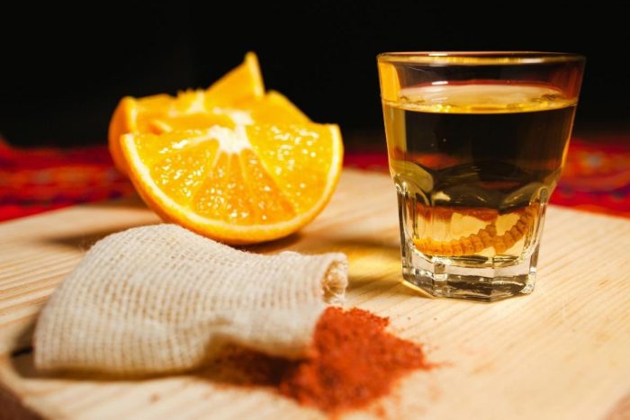 Chupar una rodaja de naranja marinada con sal de gusano antes de darle un trago de mezcal, es una tradición.